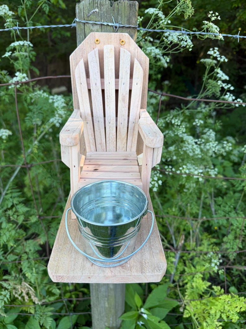 Handmade cedar Adirondack chair squirrel feeder mounted on a fence post