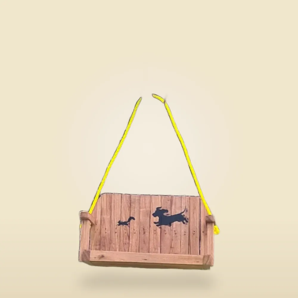 A cedar swing with two dachshund silhouettes cut into the back panel, hung on rope