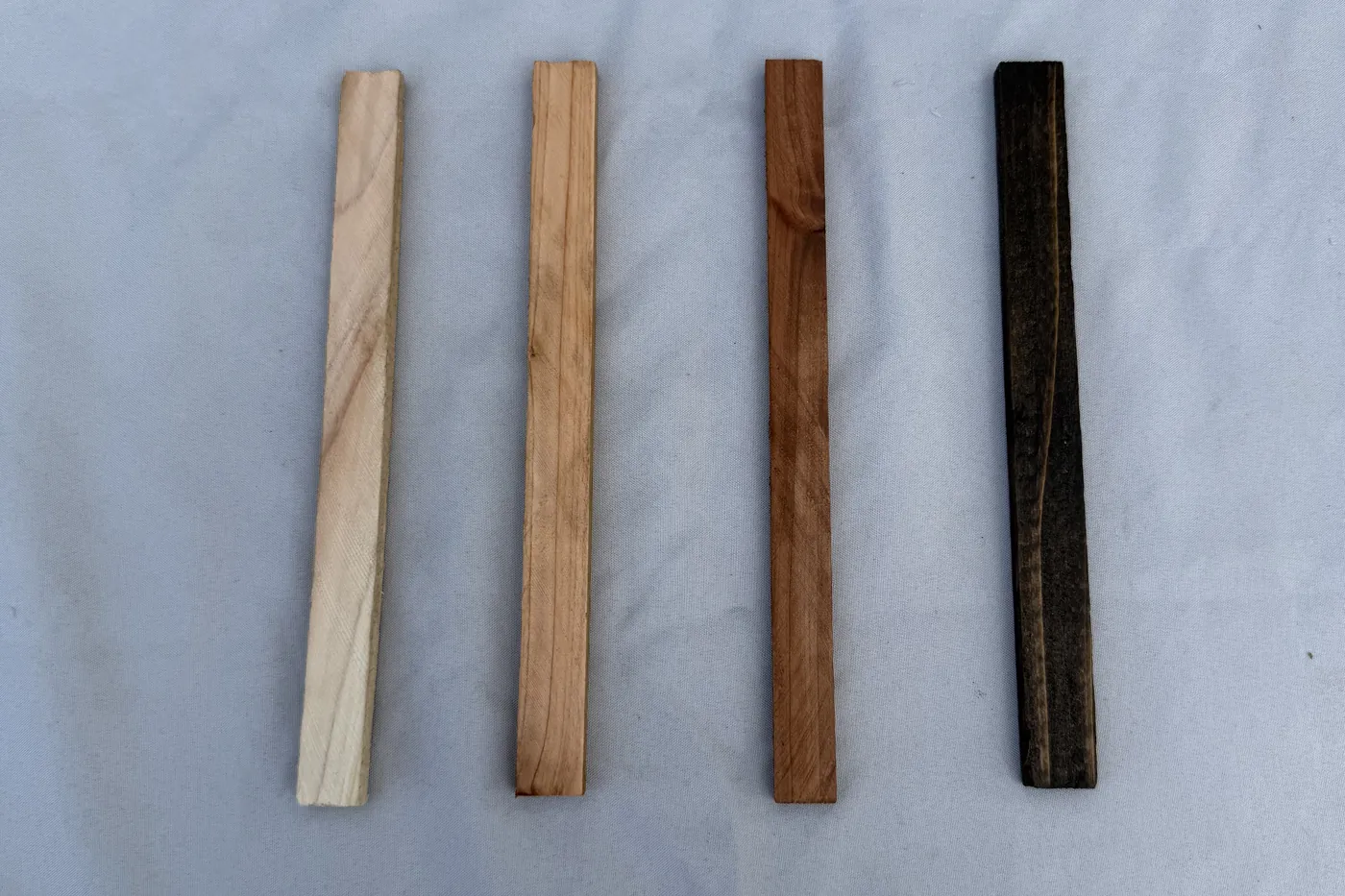 Harley's four cedar finish sample sticks laid side by side, running from the palest natural finish through to the darkest.