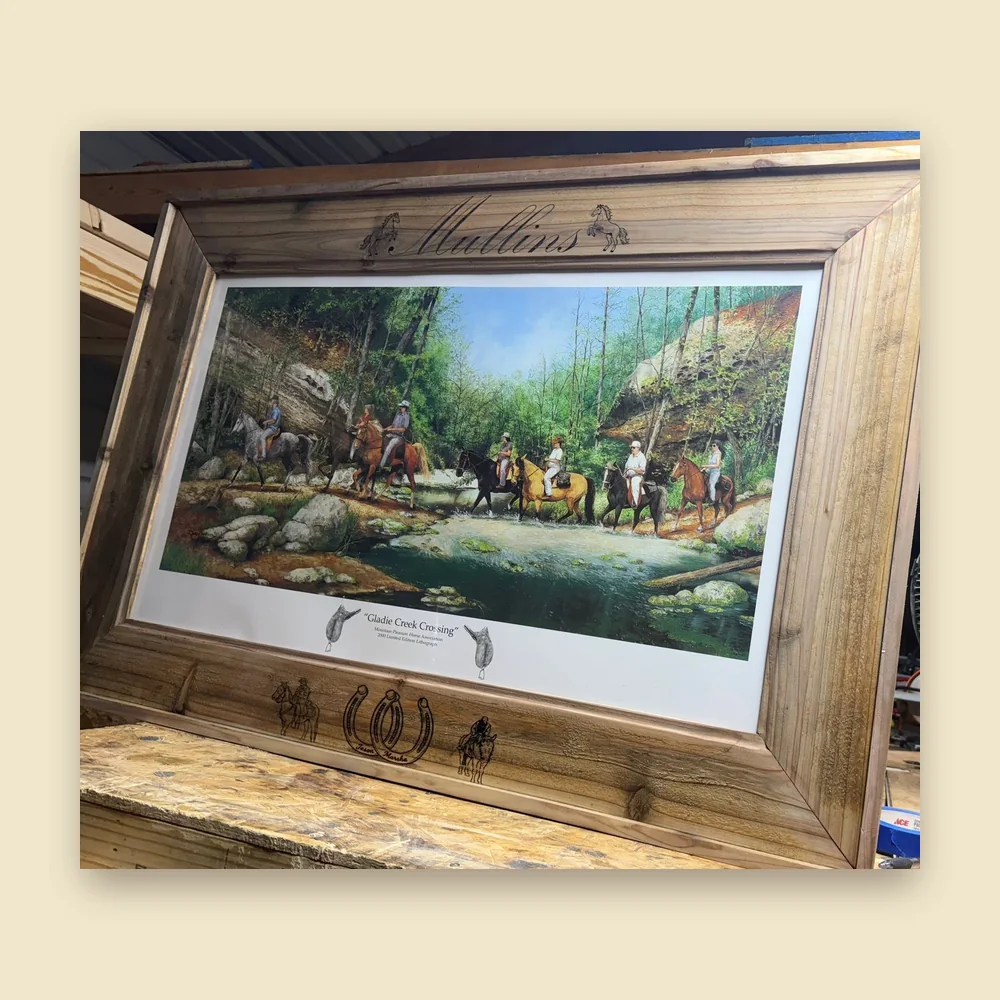 Custom-built wood picture frame with engraved lettering, on the workbench
