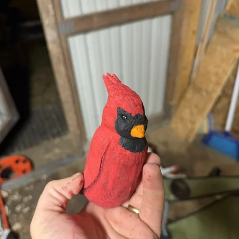 The finished cardinal, carved from a block and painted red by hand