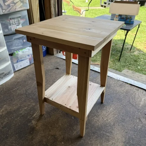 A side table in bare pine, square top and a lower shelf