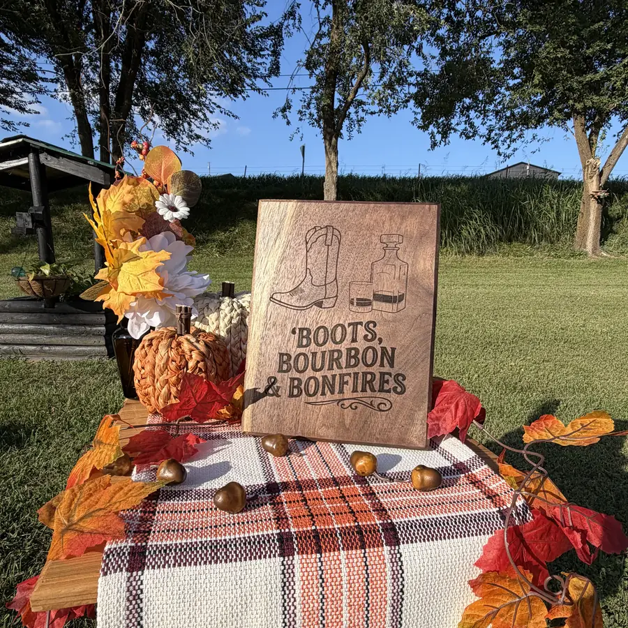 Solid black walnut plaque with a boot, a decanter and the words boots bourbon and bonfires burned into the wood