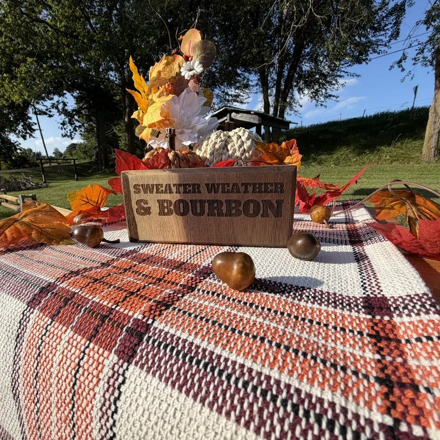 Solid black walnut sign block with the words sweater weather and bourbon burned into the wood