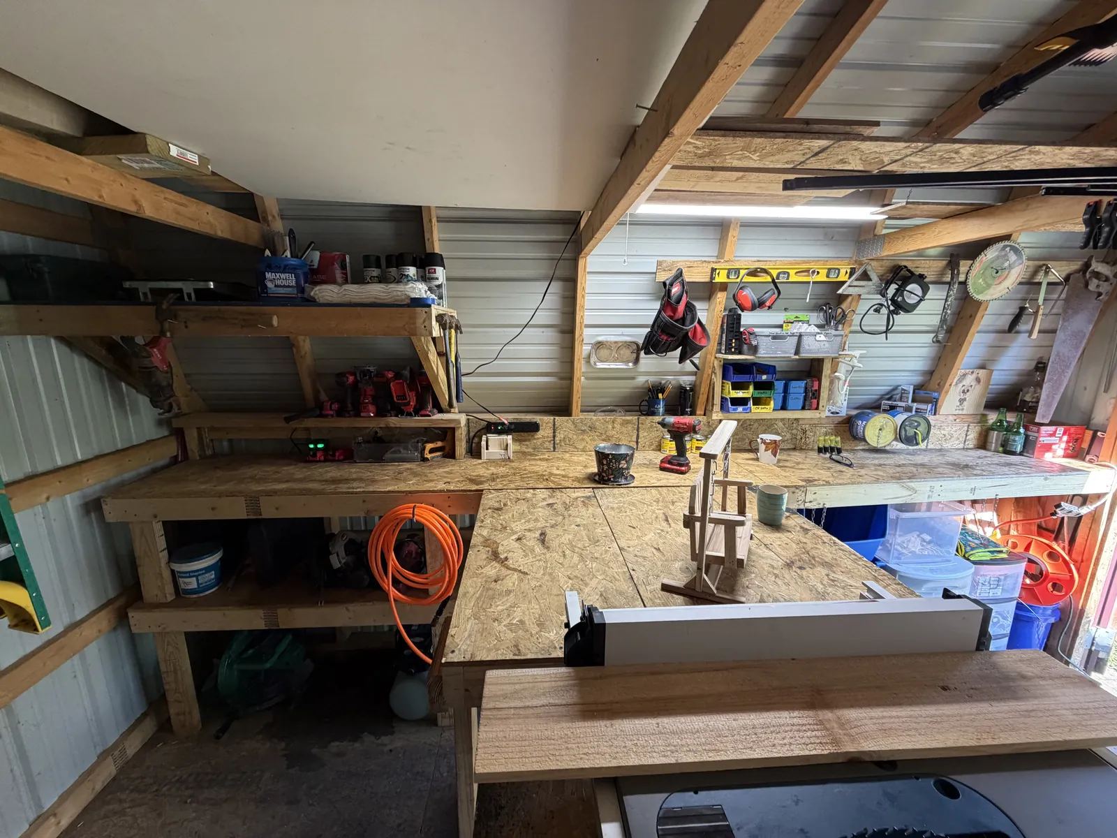 The bench: clamps on the rail, a piece clamped mid-build, shelves of finishes and offcuts